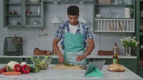 Young Adult Singing and Cooking in Kitchen