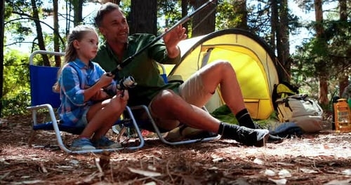 Father teaching son to use fishing rod in the park