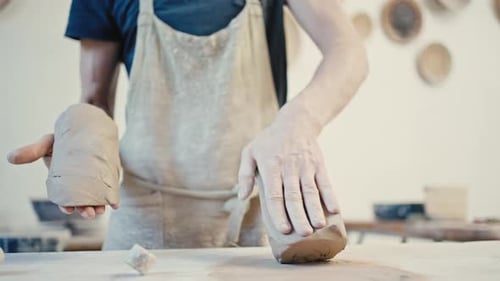 Potter Shaping Clay in Bright Studio