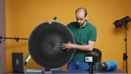 Man Demonstrating Photography Light Modifier in Studio