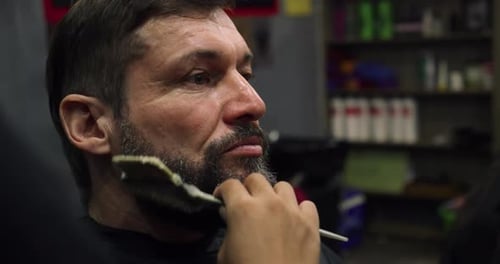 Handsome Man in a Barbershop Shaves His Beard in a Hair Studio