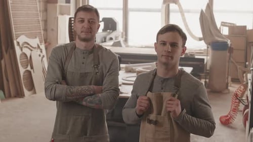 Portrait of Two Carpenters in Woodworking Workshop