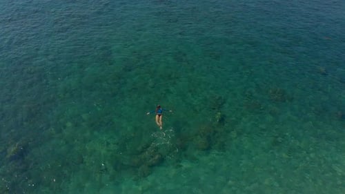 Aerial Shot of a Woman Snorkeling in a Turquoise Sea