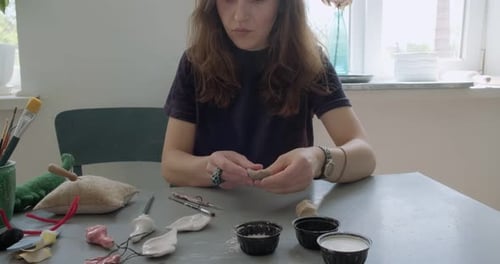 Woman Shaping Brown Clay in Bright Studio