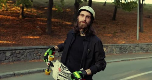 Bearded Man with Skateboard in Park
