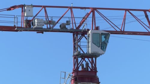 Tower crane cabin close-up on the blue sky background, Urban development concept