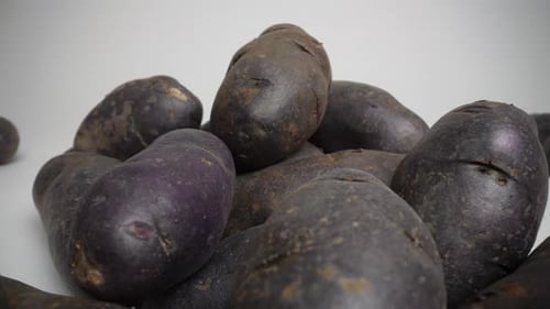 Close Up of Vibrant Purple Potatoes on White