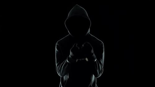 Silhouette d'un homme menotté en sweat à capuche, criminel dangereux puni par la loi