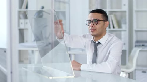 Arabischer Büroangestellter nutzt transparenten VR-Touchscreen im Büro