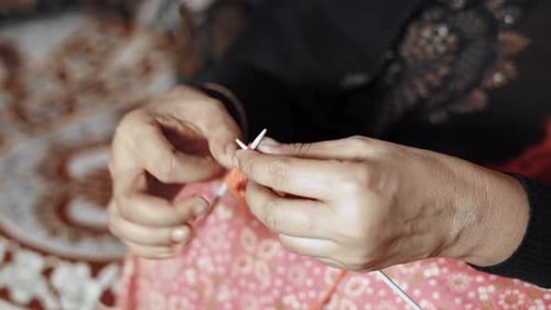 Woman's hands knitting with craft needles and red wool. 4k Close up of knit work tie-up hand work