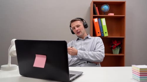 A Young Man Works From Home Leads an Online Conference with the Boss and Employees
