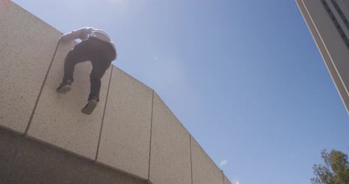 Young Man Climbing Urban Wall Doing Parkour