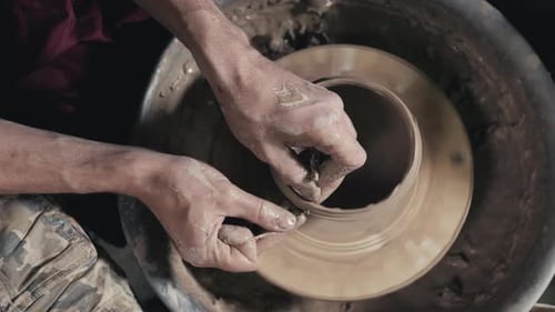 Mains du maître potier et vase d'argile sur le tour du potier en gros plan