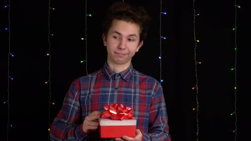 Teen Boy Looks at Gift in Box