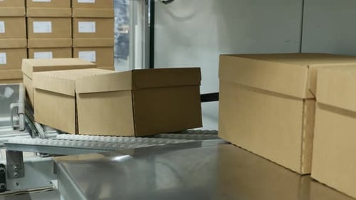 Boîtes en carton sur un convoyeur dans un entrepôt de distribution