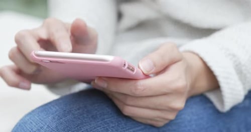 Woman Using Smartphone Touchscreen in Bright Light