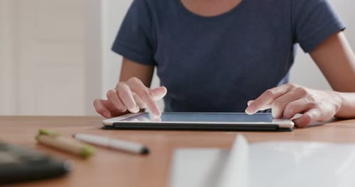 Woman Using Tablet at Table Indoors