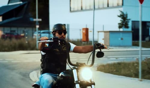 Man Riding Motorcycle on Suburban Street