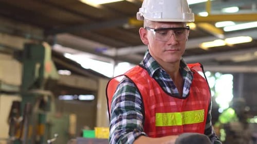 Caucasian engineer foreman writing on repair checklist of factory machine