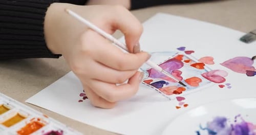 Close Up of Hand Painting Watercolor Hearts