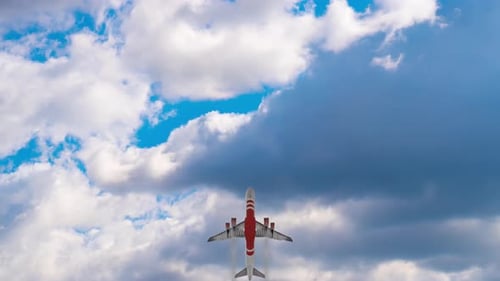 Commercial Airplane Taking Off into Blue Sky with Clouds