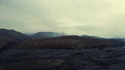Aerial view over bare hills, towards the basin of the Fagradalsfjall Volcano - orbit, drone shot