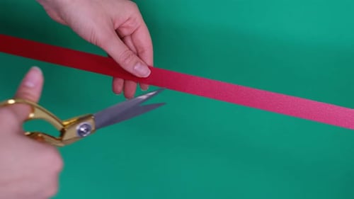 Hand with Scissors Cutting Red Ribbon Opening Ceremony Concept