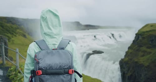Mulher viajante com mochila em frente à bela cachoeira Gullfoss