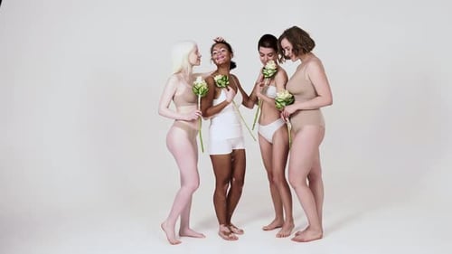 Diverse Women Smiling and Embracing, Holding Flowers