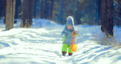 L'enfant est sur la route dans la forêt d'hiver