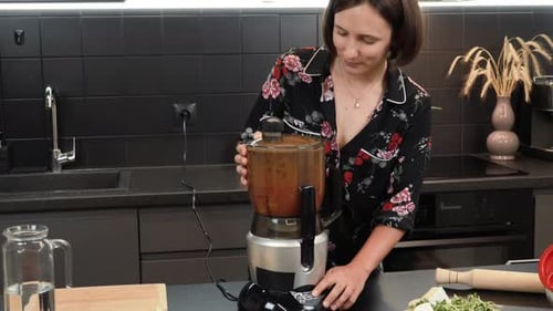 Woman Prepares Food with Food Processor in Kitchen
