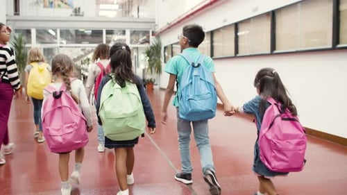 Medium Shot of Children Walking in School Hallway