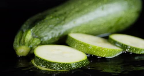Fresh Zucchini Squash with Slices on Black Surface