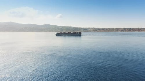 Big Container Ship Sails in the Blue Sea at Distance