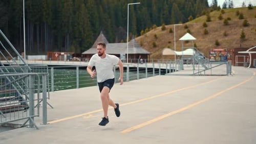 Young man running fast and intense in forest