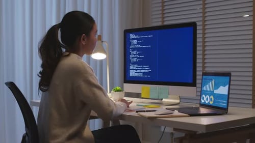 Une
scientifique des données asiatique travaille à la maison pendant la nuit dans un programme informatique.