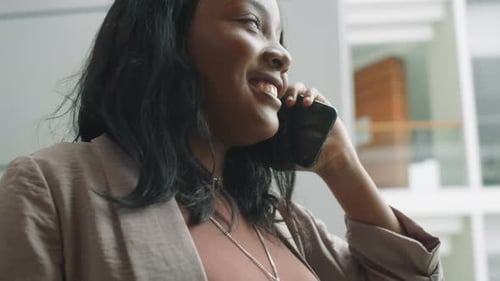 Smiling Woman Talking on Mobile Phone Indoors