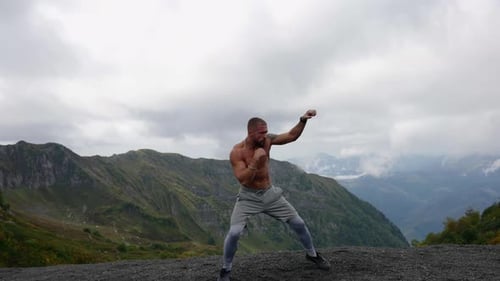 Muscular Man Boxing in the Mountains