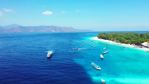 Vivid colors of tropical bay with deep blue sea and turquoise lagoon around white beach of island wi