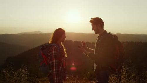 Man Proposes to Woman on Mountain at Sunset
