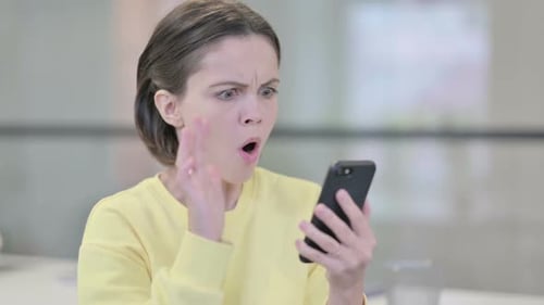 Woman Reacts With Shock While Using Phone