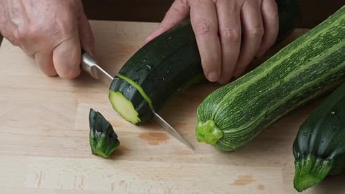 Slicing Green Zucchini on Wooden Cutting Board