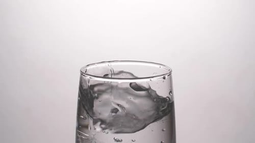 Ice Cubes Dropping into a Glass of Water