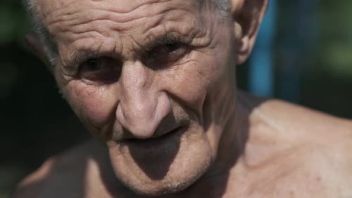 Old Man Looks with Tired and Exhausted Expression on Face
