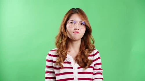 Woman Pointing Angrily in Front of Green Background