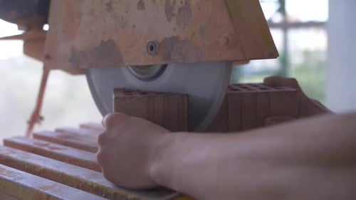 sawing red brick with a circular saw