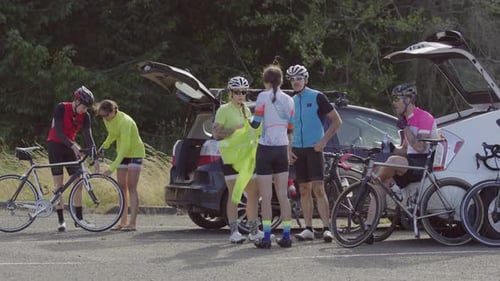 Group of cyclists taking break and preparing for ride. Fully released for commercial use.