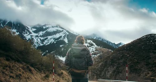 Traveler Photographer Walk on Empty Mountain Road on Hike Journey