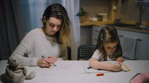 Woman and Child Drawing Together at Kitchen Table