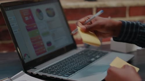 Mitarbeiter platzieren Haftnotizen als Erinnerung an die Arbeit auf dem Laptop-Bildschirm
